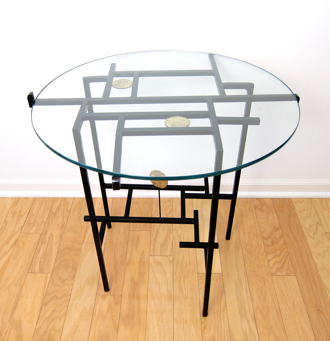 Black-painted steel end table with a glass top, sold by Etsy shop ObjectOfBeauty.